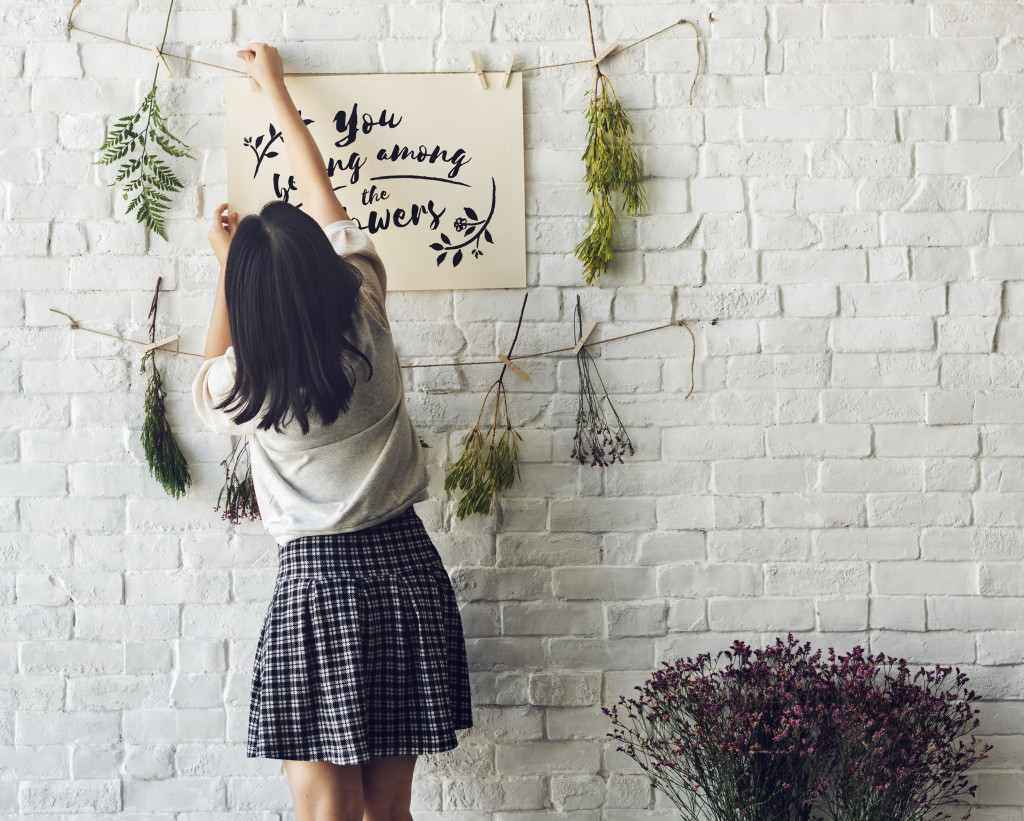 Young girl decorating a brick wall free image