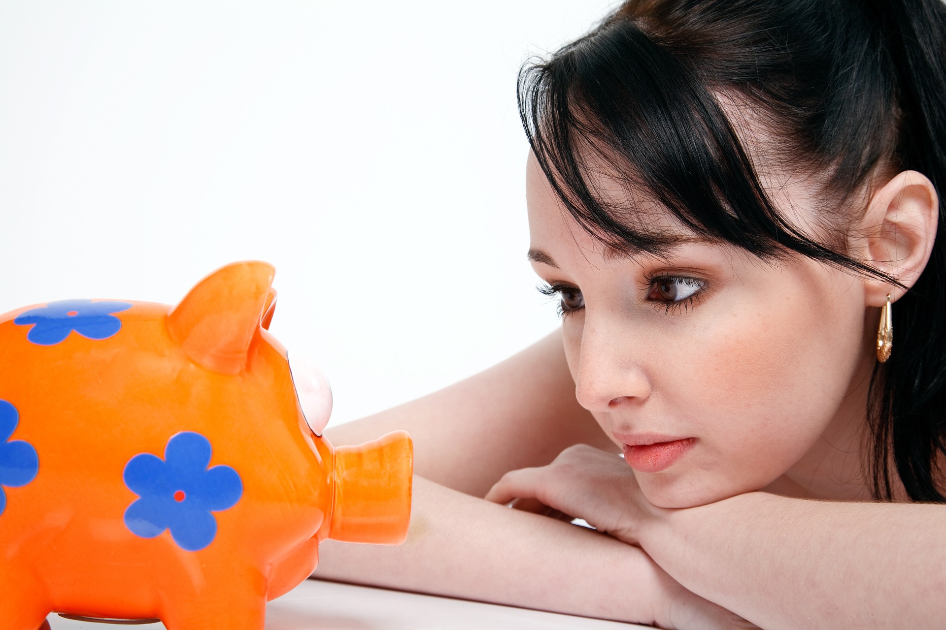 Woman staring at a colorful piggy bank